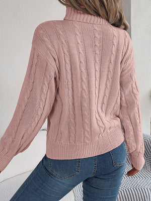 Dusty pink cable knit turtleneck sweater with voluminous sleeves and ribbed cuffs.