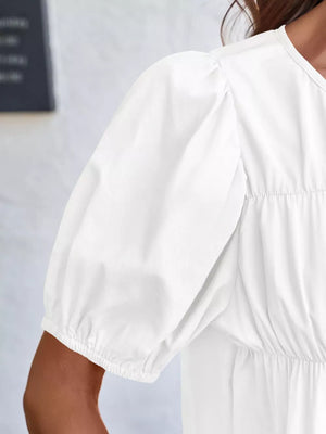 White maternity blouse with puff sleeves and ruffled detail.