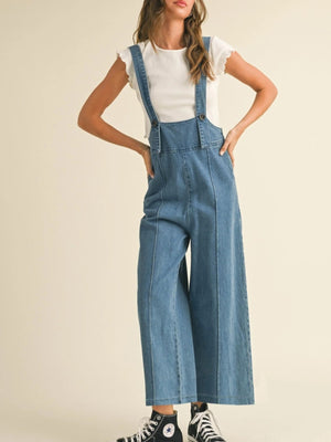 Denim wide leg overalls with adjustable straps and button details, styled with a white top.