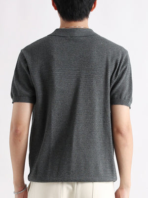 Classic short-sleeve polo shirt in grey cotton with a textured knit and button detail.