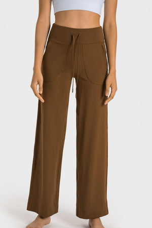 Brown wide-leg jogger trousers with drawstring waist and utility pockets.