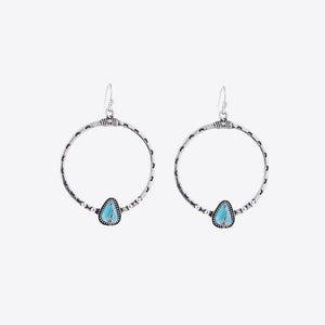 Silver Southwestern hoop earrings with turquoise teardrop stones and beaded details.