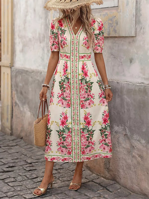 Charming floral v-neck midi dress with short puff sleeves and defined waist, styled with a straw hat.