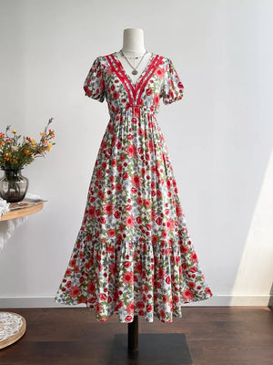 Vibrant floral v-neck midi dress with red trim and tiered skirt.