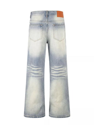 Men's vintage wash wide leg jeans in light blue cotton denim with distressed detailing.