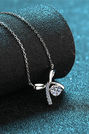 Silver bow-tie diamond pendant necklace with a clear round-cut diamond and pave accents.