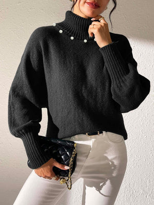 Black knit sweater with pearl details on the neckline and dolman sleeves.