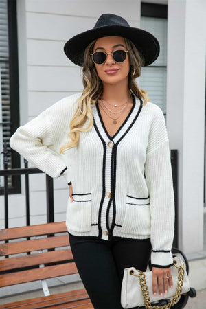 White acrylic cardigan with black trim and pockets, V-neck, button front, long sleeves.
