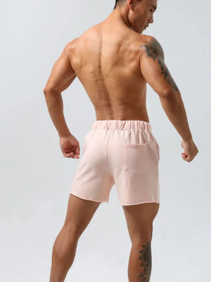 Blush pink lounge shorts with raw-edge hem and back pocket.