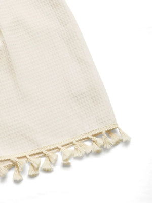 Beige textured romper with tassel trim detail