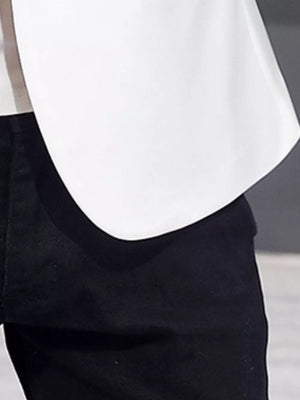 White double-breasted blazer with black trim detail over black pants