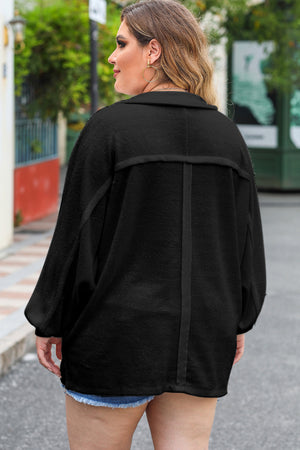 Black oversized button-down shirt with textured fabric and wide sleeves.