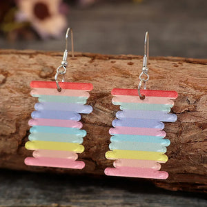 Prismatic spool acrylic earrings in multicolor with rainbow stripes and alloy hooks.