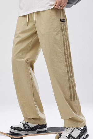 Khaki casual drawstring sweatpants with side stripes and a logo patch.