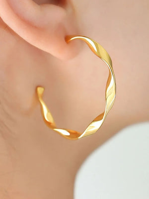 Gold twisted hoop earrings with a sculpted design.