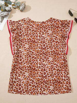 Smocked ruffled print blouse with animal pattern and red trim on sleeves.