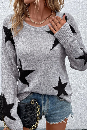 Gray knit jumper with black star pattern, crew neck, long sleeves.