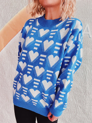 Blue acrylic knit jumper with allover white geometric heart pattern, crew neck, long sleeves.