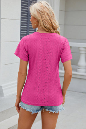 Eyelet wrap V-neck top in hot pink with short sleeves and a textured pattern.