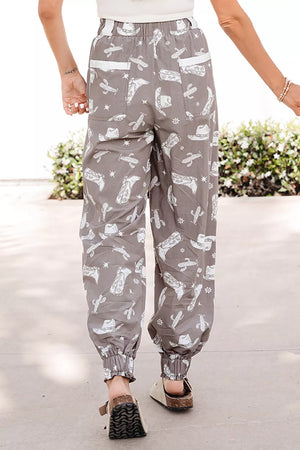 Grey cotton joggers with white western print, drawstring waist, elastic cuffs, and white pocket details.