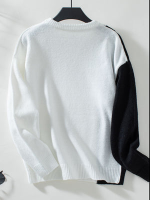 Colorblock knit sweater in white with black raglan sleeves and crewneck.