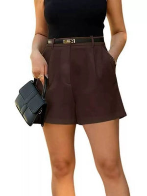 High-waisted pleated shorts in dark brown with a black belt and pockets.