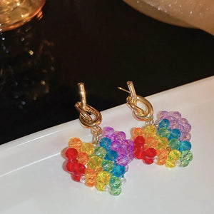 Rainbow heart beaded drop earrings with gold knot detail.