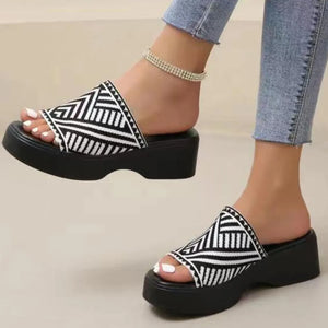 Platform knit slide sandals in black and white geometric pattern with a thick sole.
