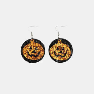 Glitter pumpkin Halloween dangle earrings with black glitter circles.