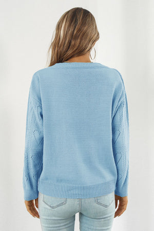 Light blue acrylic V-neck knit pullover sweater with heart stitch detail on sleeves.