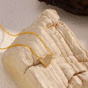 Gold necklace with a rhinestone heart pendant.