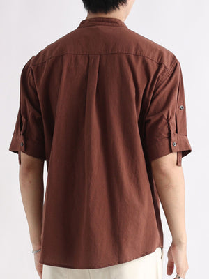 Brown band collar button-down blouse with roll-tab sleeves and back pleats.