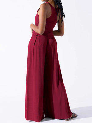Burgundy square neck palazzo jumpsuit with wide legs and pleats.