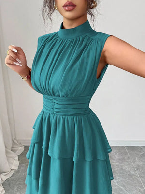 Sleeveless teal ruffled tiered dress with ruched waist and mock neck.