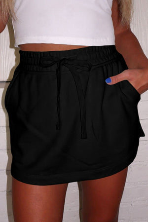 Black French terry skort with drawstring waist and pockets.