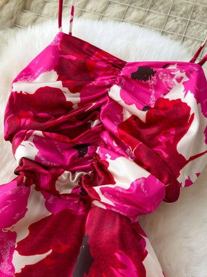 Vibrant floral cami dress with ruched bodice and spaghetti straps.