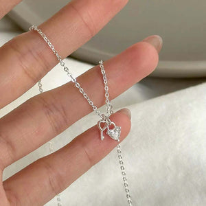 Sterling silver necklace with heart lock and key charms, one with a crystal accent.