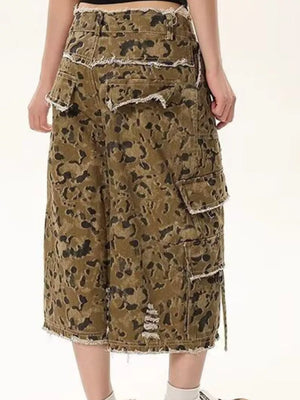 Men's distressed camo denim shorts with frayed hem and cargo pockets.