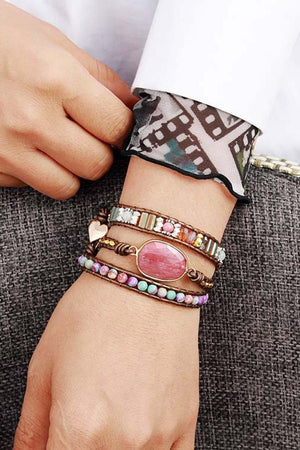 Bohemian wrap bracelet with pink stone, beads, and heart charm on leather band.