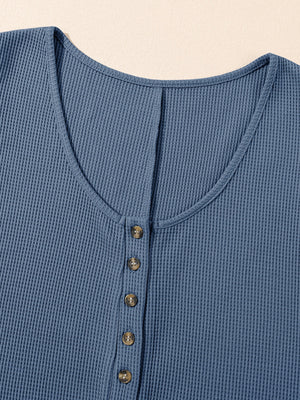 Dusty blue waffle knit button-down romper with a V-neck and wooden buttons.