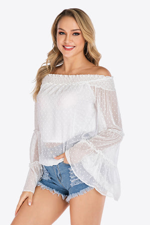 White dotted swiss off-shoulder blouse with ruffle bell sleeves and smocked neckline.