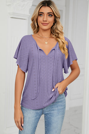 Lavender eyelet tie-neck blouse with flutter sleeves and a v-neckline.