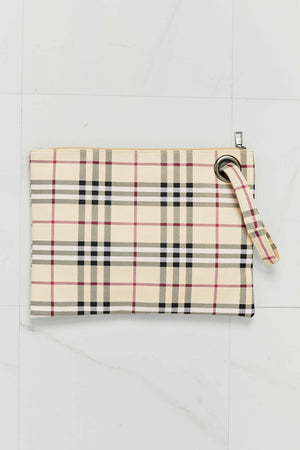 Plaid print wristlet clutch bag in cream/black with grommet detail and wrist strap.