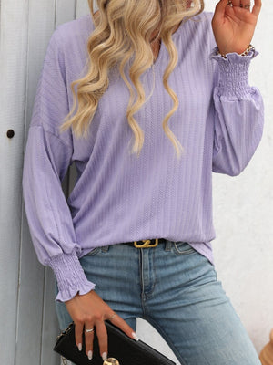 Lilac textured blouson top with smocked cuffs and v-neck