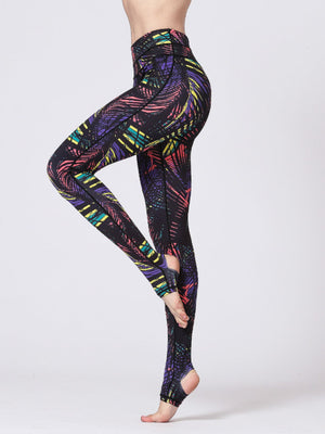 Black stirrup leggings with a colorful palm leaf print and high waist.