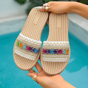 Bohemian woven strap flat sandals with colorful embroidered detail and white lace trim.