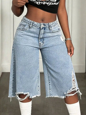 Light wash distressed wide-leg denim shorts with raw hem and ripped details.