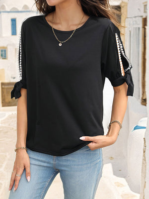 Black split sleeve blouse with lace trim and tie details, crew neck, short sleeves.