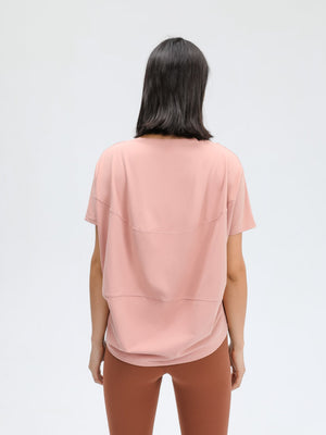 Relaxed fit performance tee in pink with short sleeves and layered detail.