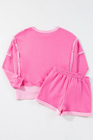 Pink loungewear set with ruffled seams and contrast trim.